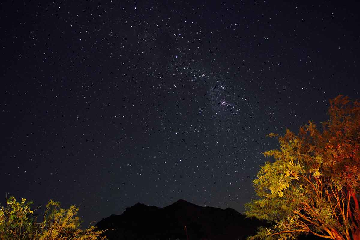 Looking out at a mountain on a starry night