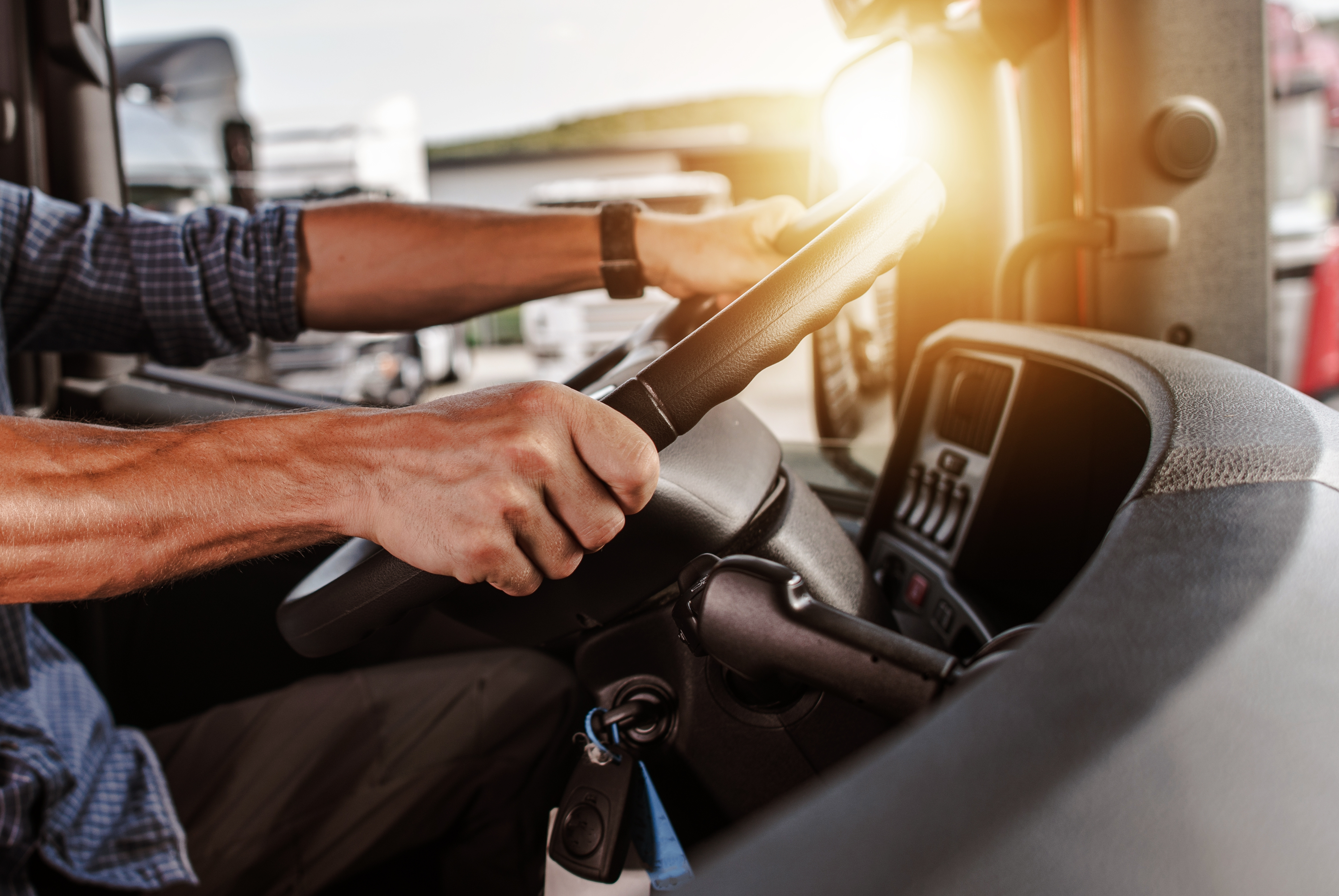 Hands gripping a truck steering wheel
